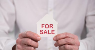 Emlakçı satılık bir ev tutuyor; satılık ev kavramı