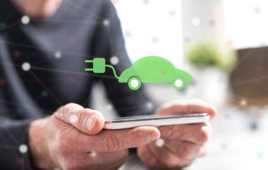 Çevre dostu araba konsepti olan akıllı telefonu tutan adamın elleri.