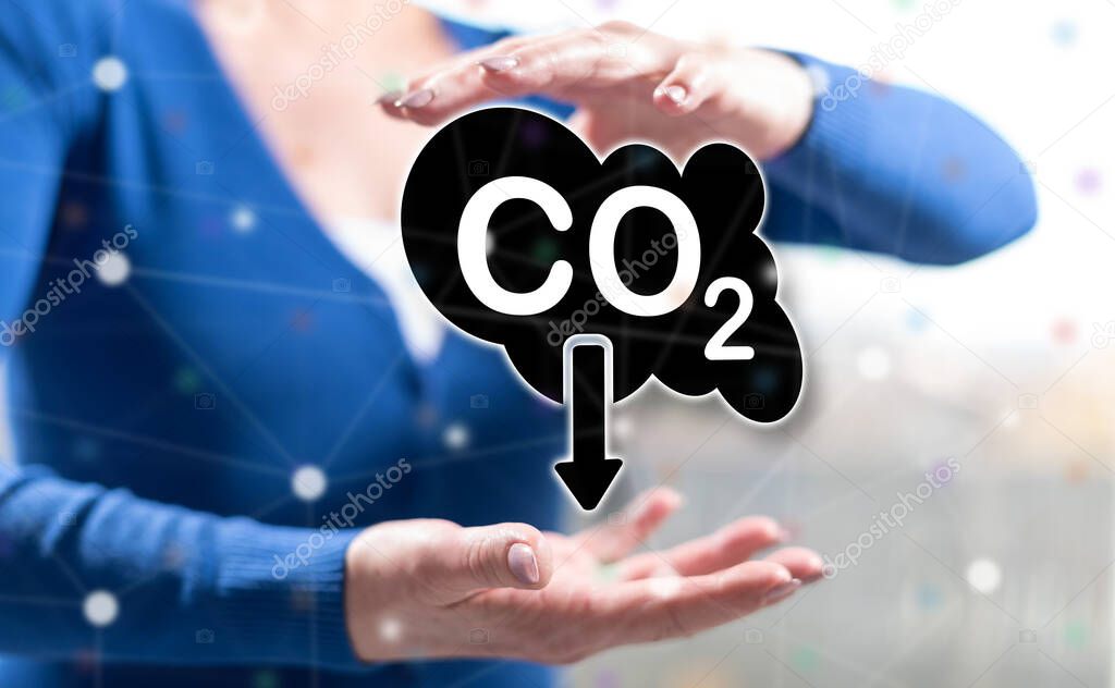 Carbon reduction concept between hands of a woman in background