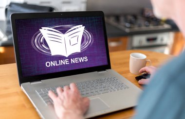 Ekranda online haber konsepti olan bir dizüstü bilgisayar kullanan adam