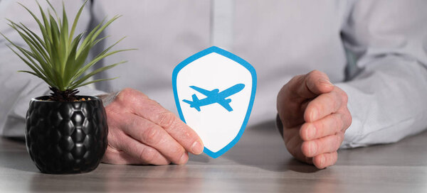 Concept of flight insurance with paper shield held by female hand