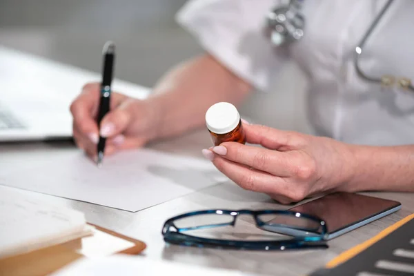 Female Doctor Looking Bottle Pills Writing Prescription Medical Office — Stock Photo, Image