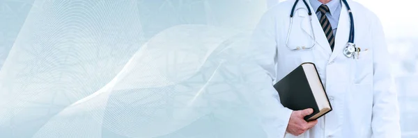 Doctor standing and holding a medical textbook; panoramic banner
