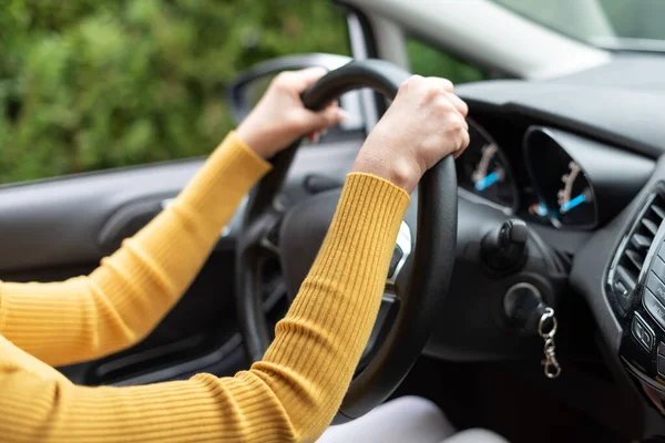 女人用双手在方向盘上开车 — 图库照片