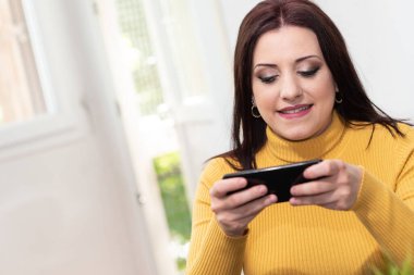 Genç iş kadını cep telefonunu kullanıyor.