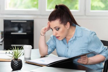 Dosyadaki belgeye bakan sürpriz iş kadını