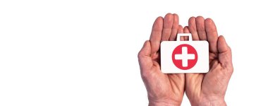 Sağlık sigortasının sembolü olan beyaz üzerine izole edilmiş bir evrak çantası tutan eller