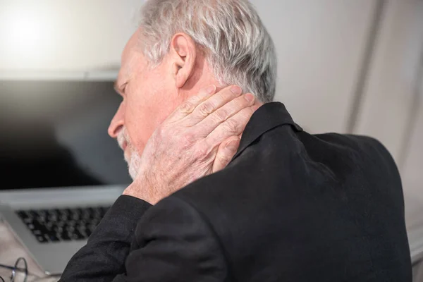 Senior businessman suffering from neck pain
