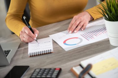 İş kadını pazarlama verilerini analiz ediyor ve not alıyor