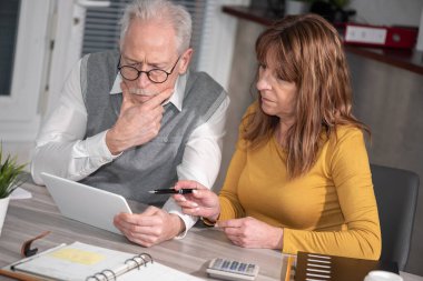 Ofiste dijital tablet üzerinde çalışan iki olgun iş arkadaşı
