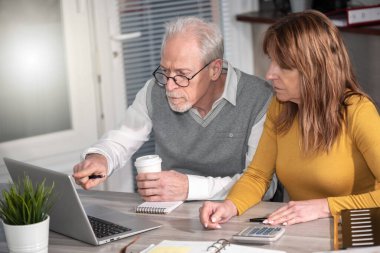 Ofiste dizüstü bilgisayarda çalışan iki yetişkin iş arkadaşı.