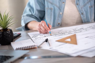 Yeni inşaat projesinin taslağı üzerinde çalışan kadın mimar.