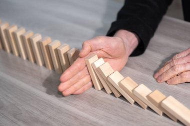 Erkek eli domino etkisini durduruyor. İş denetimi kavramı