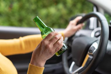 Araba kullanırken içki içen kadın