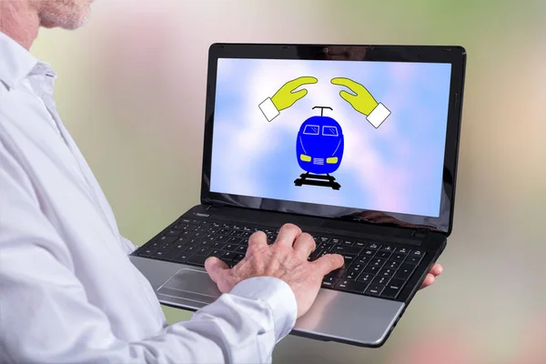Man using a laptop with train insurance concept on the screen