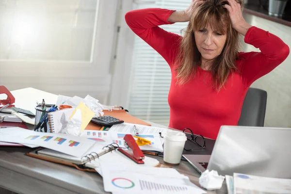 Überarbeitete Reife Geschäftsfrau Sitzt Einem Chaotischen Schreibtisch — Stockfoto