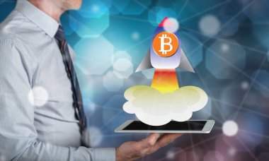 Bitcoin yükselme kavramı bir adamın elinde tuttuğu tabletin üzerinde