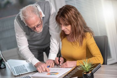 Ofiste mali istatistikler üzerinde çalışan iş arkadaşları
