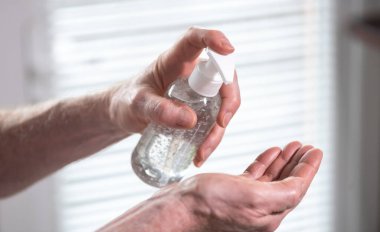 Dezenfektan alkol jeli şişesine el basımı; virüs ve bakteri enfeksiyonunun önlenmesi