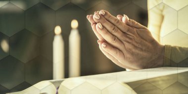 Elleri İncil 'in, sert ışığın, geometrik desenlerin üzerinde dua eden kadına yakın durun.