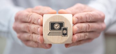 2fa kavramının sembolü olan ahşap bir küpü tutan el.