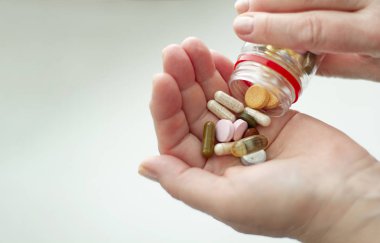 Renkli haplar, hafif bir arka plan üzerinde avuç içinde vitaminler.