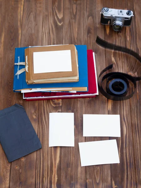 Old photo albums with photographic film on a brown wooden table.