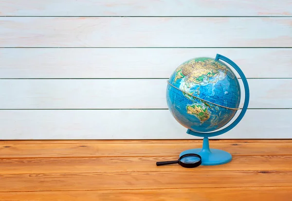 Globe, Earth model, educational material on a wooden table on a blue background. Asia. Australia.Copy space.Horizontal.