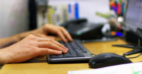 A man in the office works with a computer on a monitor background.