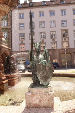 INNSBRUCK, AUSTRIA - 13 Mayıs 2015 'te Innsbruck' ta Rudolf Çeşmesi önünde kollar ve bayraklar bulunan Tyrolean Eagle (Tiroler Adler) heykeli. 1877 'de dikildi..
