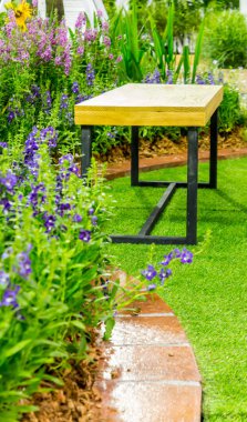 Ahşap koltuk ve çiçek pot dekorasyonda rahat ev çiçek bahçesi yaz. 