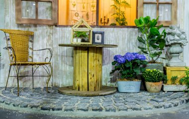 Tablo kümesi ve çiçek alanıyla rahatlatıcı rahat ev penceresinde yakınındaki pot.