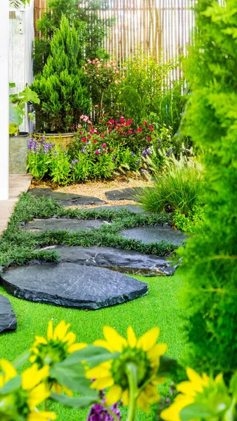 Stone walkway with flower pot and garden object decoration in cozy home flower garden on summer.