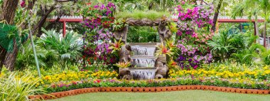 Şelale rahat ev çiçek bahçesinde akar