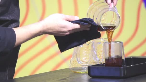 影片展示滴咖啡壶和咖啡师添加现成的滴咖啡喝在杯子 — 图库视频影像