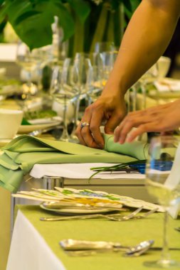 Garson eller partide yemek masasında dekorasyon için peçete katlama.