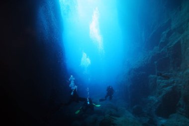 Okyanustaki su altı mağaraları ve tüplü dalgıçlar.