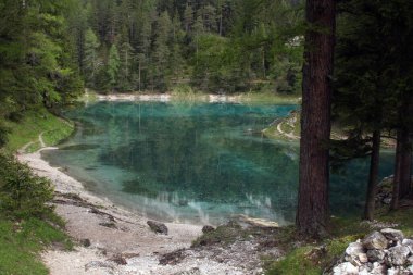Yüksek dağların ortasında yeşil alp gölü. Suyun yeşil rengi sayesinde çok nadir görülür..