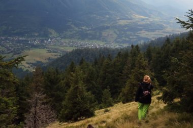 Karpatya dağlarında gezinti. Tepeden inen kız Sinevir manzaralı arka planda.