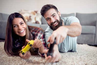 Evde video oyunu oynayan genç çift