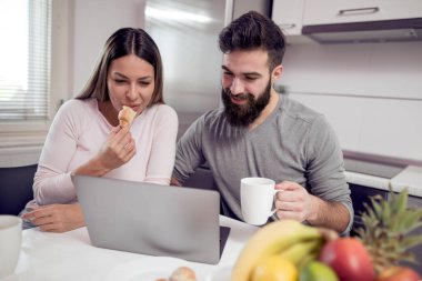 dizüstü bilgisayar kullanarak ve evde video izlerken genç çift oturma