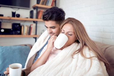 Genç çift rahatlatıcı ve evde kahve içme