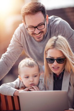 Aile eğleniyor ve izlerken açık havada tablet PC'de karikatürler