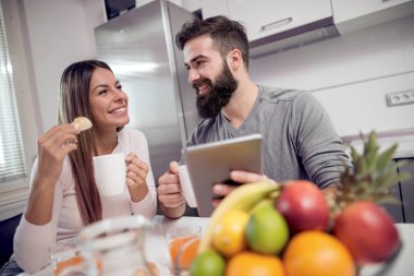 Tablet izliyor ve kahvaltı genç çift