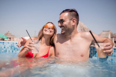 Genç çift, yaz yüzme havuzunda rahatlatıcı