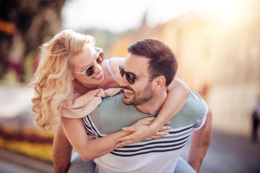 Açık havada eğleniyor ve gülümseyen genç çift