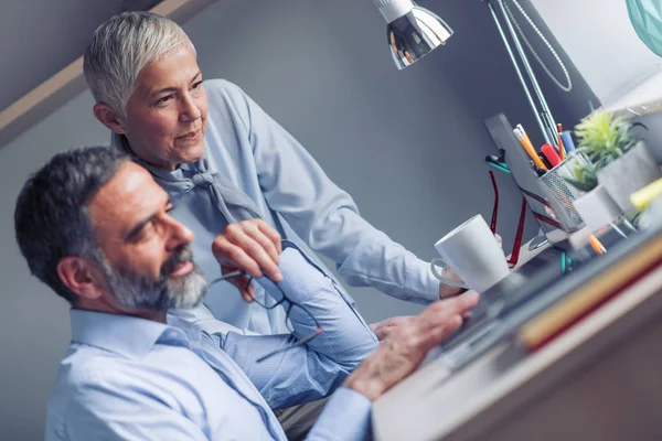 Business people using laptop and discussing new ideas while working together in office