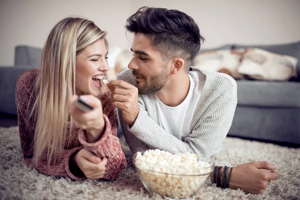 テレビを見て 家でポップコーンを食べる若いカップル — ストック写真