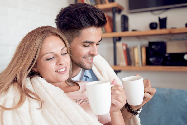 young couple relaxing and drinking coffee at home