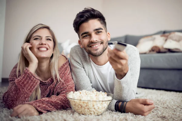 年轻夫妇在家里看电视和吃爆米花 — 图库照片